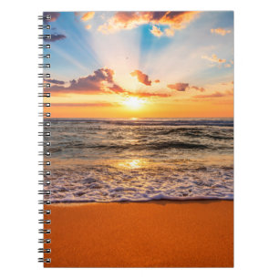 Colorful ocean beach sunrise with deep blue sky an notebook