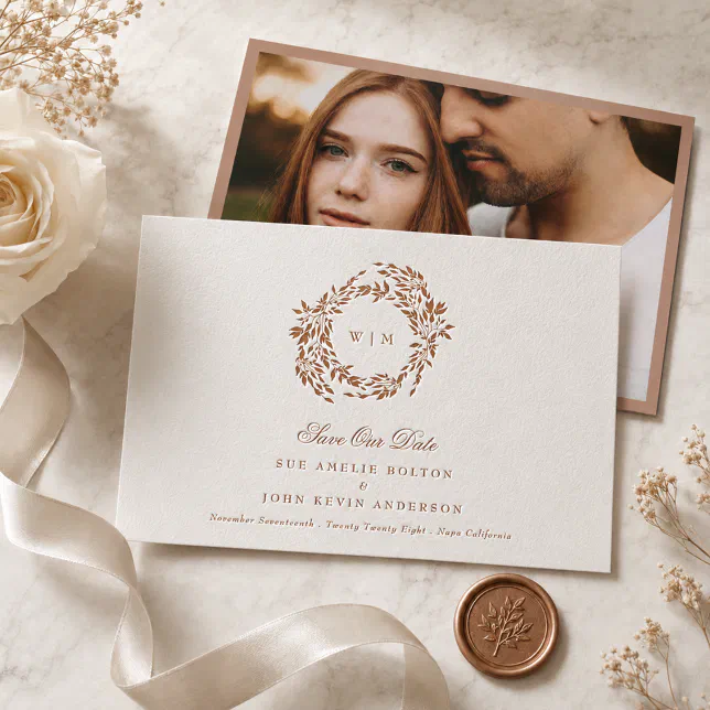 A copper-colored Save the Date with a floral wreath and a photo of the couple on the back.