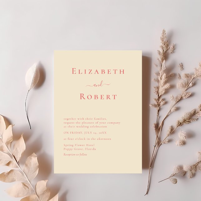 Coral Modern Minimalist Script Wedding Invitation (Coral Modern Minimalist Script Wedding Invitation on a table with soft pink dry flowers)