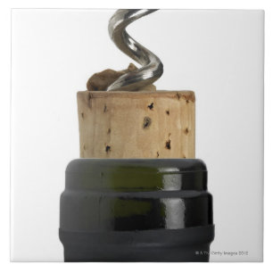 Corkscrew and cork, photographed on white ceramic tile