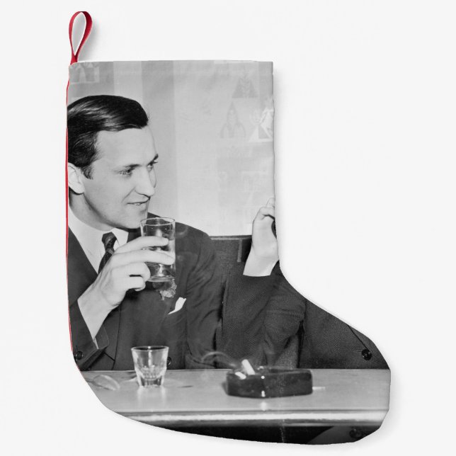 Couple sitting together in a restaurant flirting w small christmas stocking (Front)