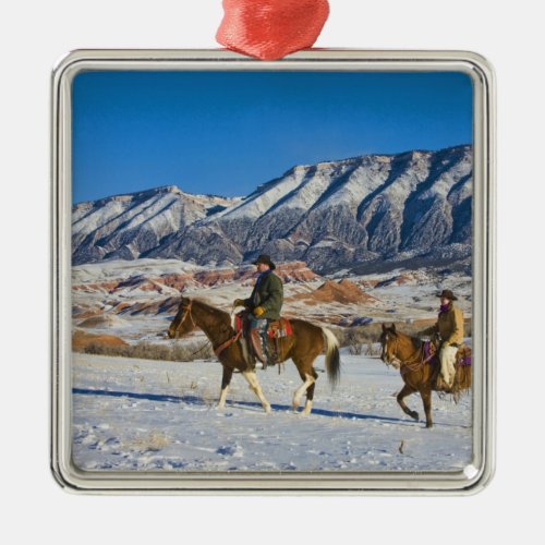 Cowboy and Cowgirl riding Horse through the Snow Metal Ornament