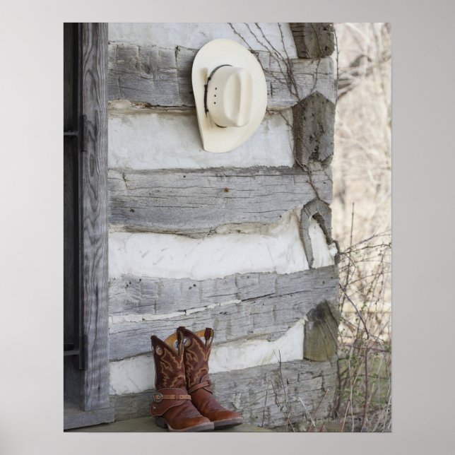 Cowboy boots and hat outside of log cabin poster (Front)