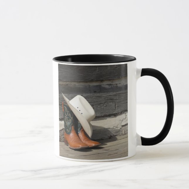 Cowboy hat on cowboy boots outside a log cabin mug (Right)