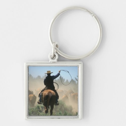 Cowboy on horse with lasso driving cattle keychain