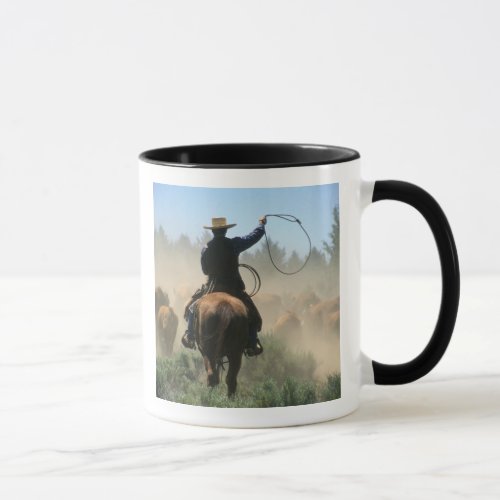 Cowboy on horse with lasso driving cattle mug