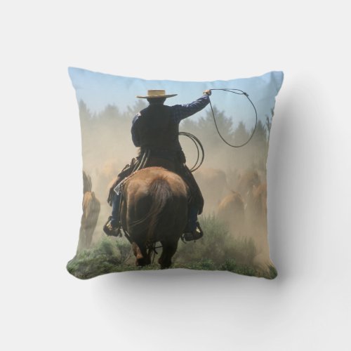 Cowboy on horse with lasso driving cattle throw pillow