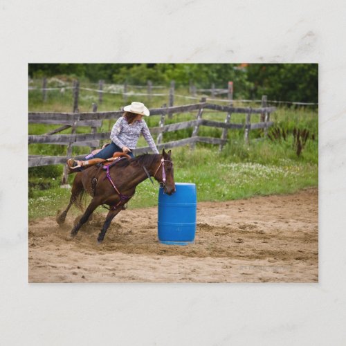 Cowgirl on horseback practicing barrel racing in postcard