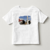 Cows in front of a red barn and silo on a farm