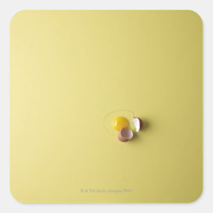 cracked egg on yellow background square sticker