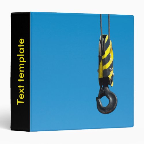 Crane hook with yellow and black stripes hanging 3 ring binder