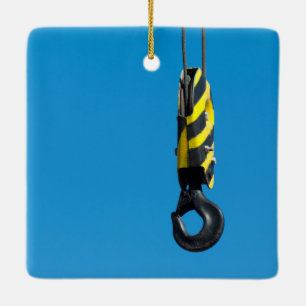 Crane hook with yellow and black stripes hanging ceramic ornament