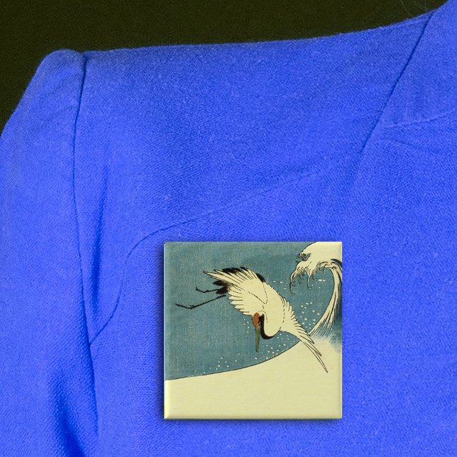 Crane In Ocean Wave Pinback Button (Black white crane bird flying over tall ocean wave on blue square pin back button.)