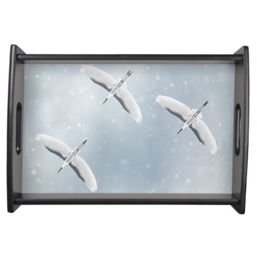 Cranes flying on the winter sky in silent snowfall serving tray