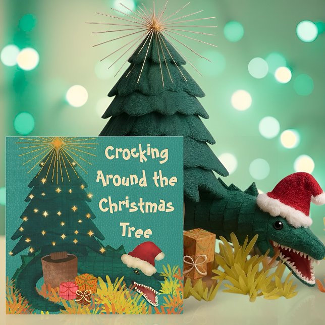 Crocking Around Christmas  (Funny Christmas card with a crocodile in a Santa hat under a tree and the pun Crocking Around)