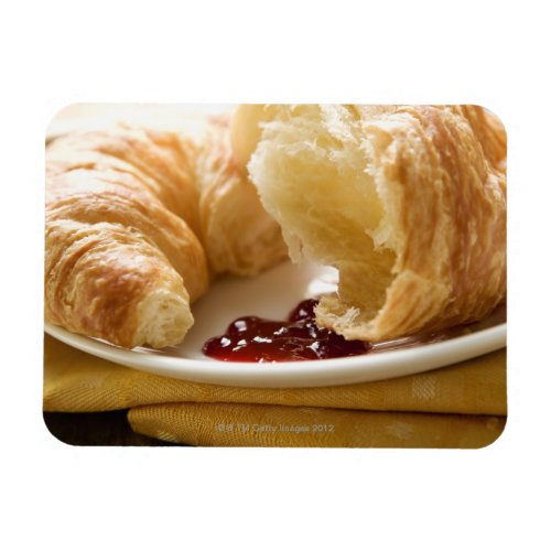 Croissant with jam on a plate magnet