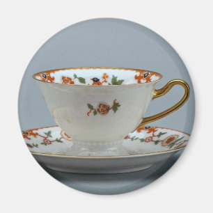 Cup and saucer with colorful flowers on it. magnet