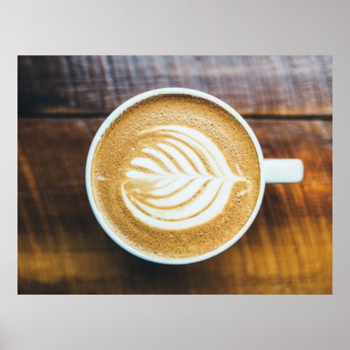 Cup of Coffee Latte with Leaf_Shape Foam on Wood Poster