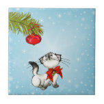 Curious Christmas Kitty With A Red Bow Ceramic Tile<br><div class="desc">A funny and cute ceramic tile with a christmas theme. A mischievous and playful white siamese cat. She is looking up at a christmas tree decoration hanging from a pine branch wondering if she should be naughty and play with it or not. Set on a blue background with white snowflakes....</div>