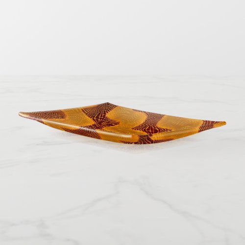 Curva laranja e pontos dourados sobre fundo marrom trinket tray