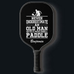 Custom Black Never Underestimate An Old Man With A Pickleball Paddle<br><div class="desc">This Pickleball paddle featuring a Pickleball player and "Never Underestimate An Old Man With A Pickleball Paddle" written in white font on black background is a perfect gift for a Pickleball lover. You can customize this design with your or your loved one's name, or remove the name by clicking "Personalize...</div>