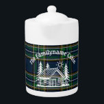 Custom Family Cabin Plaid Ceramic Teapot<br><div class="desc">Serve your favorite tea with rustic charm using this personalized ceramic teapot. Featuring a hand-drawn log cabin nestled between pine trees and a sun motif, this design sits atop a rich green and blue tartan plaid background—perfect for mountain homes, lakeside cabins, or woodland retreats. Add your family name to make...</div>