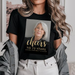 Custom Photo Cheers 70th Birthday Party T-Shirt<br><div class="desc">This 70th birthday party t-shirt features the guest of honor's photo with a gold-colored text overlay. The word "cheers" appears in elegant gold-colored calligraphy script, followed by "to 70 years" and the guest of honor's name and birthday in sans serif font. A dark screen helps make the text pop. A...</div>