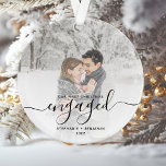 Custom Photo First Christmas Engaged Black Script Ornament<br><div class="desc">Commemorate your engagement with this beautiful modern keepsake ornament. The black text reads "Our first Christmas engaged, " with the word "engaged" in elegant handwriting script with flourishes before and after. Replace the sample image with your favorite photo, and add your names and the year. A white gradient filter helps...</div>
