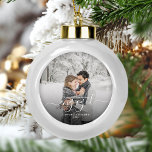 Custom Photo First Christmas Engaged White Script Ceramic Ball Christmas Ornament<br><div class="desc">Commemorate your engagement with this beautiful modern keepsake ornament. The white text reads "Our first Christmas engaged, " with the word "engaged" in elegant handwriting script with flourishes before and after. Replace the sample image with your favorite photo, and add your names and the year. A black gradient filter helps...</div>