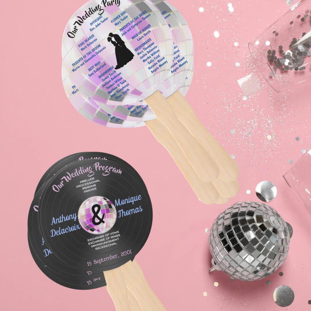 Disco-themed wedding program hand fans, one shaped like a mirror ball and one like a vinyl record, on a pink background with a small disco ball and silver confetti.