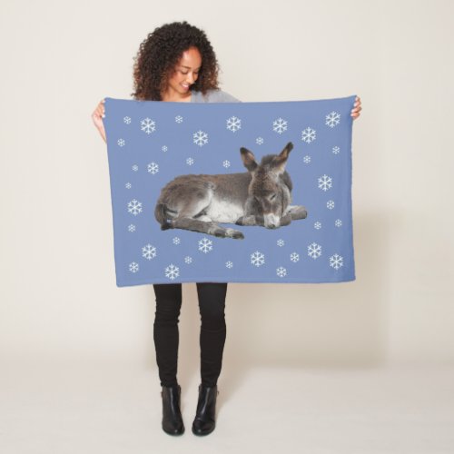 Cute baby donkey with snowflakes on blue fleece blanket
