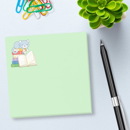 Cute Cat on top of a Book Stack on Green Post_it Notes