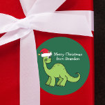 Cute Christmas Dinosaur in Santa Hat Custom Kids Classic Round Sticker<br><div class="desc">Awesome green dinosaur smiling and looking very cute in a holiday red Santa hat. Kids will love this cool green holiday party favor label. Customize these Christmas gift sticker with your own text in white.</div>