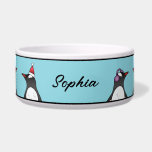 Cute Christmas Penguins On Blue With Custom Name Bowl<br><div class="desc">Destei's original illustration of cute and festive Christmas theme Gentoo penguins. One penguin is wearing a green scarf, another one is wearing purple ear protection and the third penguin is wearing a red and white Santa hat. The background color is light blue with black top and bottom borders. There is...</div>
