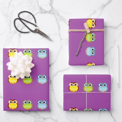 Cute colorful owls on purple wrapping paper sheets
