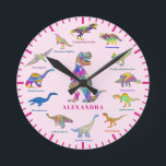 Cute Dinosaurs with names pink Round Clock<br><div class="desc">Add your child’s name in pink on a light pink background to this fun 12 Dinosaurs in colorful psychedelic bright colors with their dino names. The perfect educational design for the child who loves dinosaurs especially girls that love dinos. This fun palaeontology pattern includes all the prehistoric jurassic era favourites...</div>