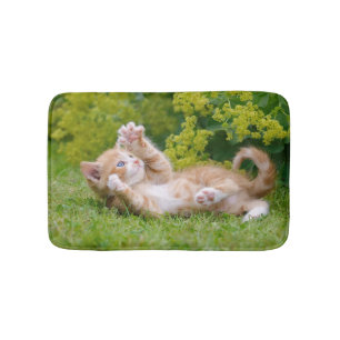 Cute funny cat kitten playing in a flowery garden bath mat