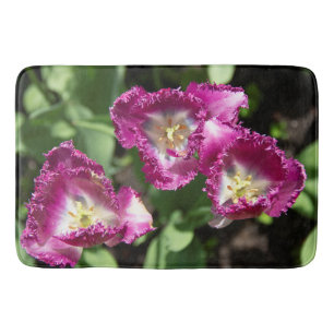 Cute purple tulips in the garden bath mat