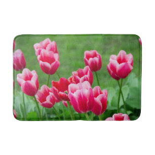 Cute scarlet tulips in the garden bath mat
