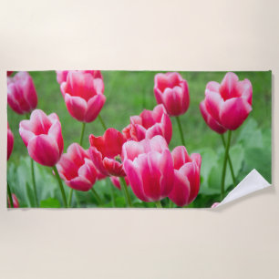 Cute scarlet tulips in the garden beach towel
