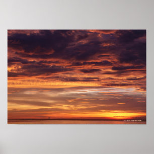 Dark clouds in orange streaked sky poster