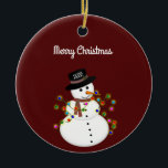 Dated Merry Christmas Snowman Personalized Ceramic Ornament<br><div class="desc">Cute snowman is tangled with lit Christmas lights, has the year on his hat - The "Merry Christmas" text above can be changed or added to, and the font style/size can also be changed. Shown on a deep red background, which can be changed to any color you prefer. The ornament...</div>