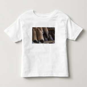 Detail of dusty bottles sur lattes on wooden toddler t-shirt
