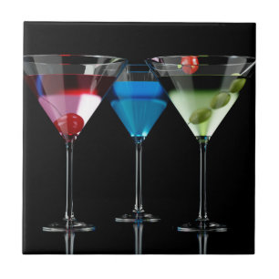 Different cocktails in martini glasses on black ceramic tile