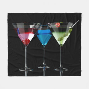 Different cocktails in martini glasses on black fleece blanket