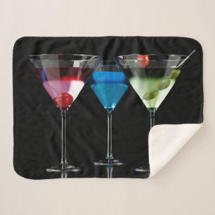 Different cocktails in martini glasses on black sherpa blanket