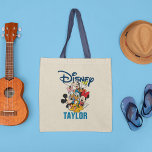 Disney | Mickey & Friends - Family Vacation Tote Bag<br><div class="desc">Celebrate your Disney family vacation with this charming tote bag featuring Mickey Mouse, Minnie Mouse, Donald Duck, Goofy, and Pluto. This playful and vibrant design is customizable with your family name, making it a perfect keepsake for your magical trip. Ideal for carrying essentials during your adventure, this tote bag combines...</div>