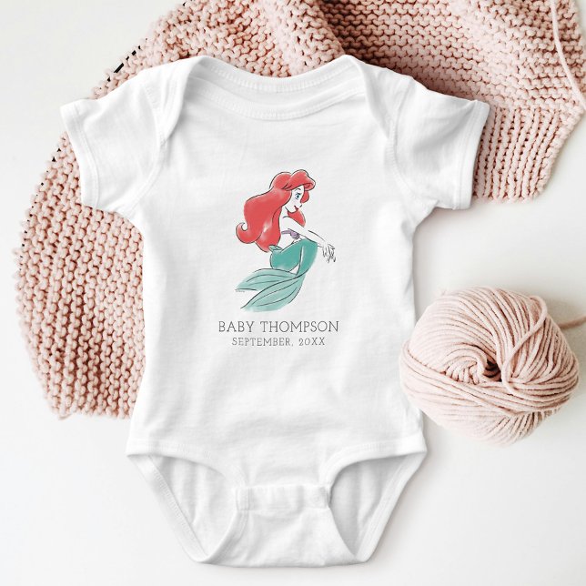 Disney Princess Ariel Announcement Date Baby Bodysuit (Bodysuit on table with knitting)