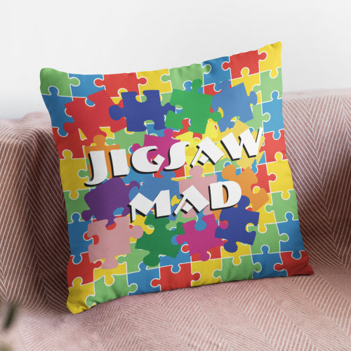 A cushion that has images of jigsaw pieces, and says jigsaw mad on it.