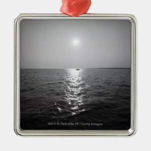 Distant boat on ocean metal ornament